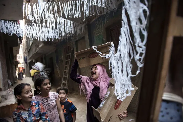Children assist in the installation of Ramadan's ornaments at the streets of Baragel, on the outskirts of Cairo, Egypt, 12 May 2018. People put up decorations and ornaments in the local tradition in Egypt as part of the celebration of the Holy month of Ramadan, which is expected to start in Egypt on 17 May 2018. Muslims around the world celebrate the holy month of Ramadan by praying during the night time and abstaining from eating, drinking, and sexual acts during the period between sunrise and sunset. Ramadan is the ninth month in the Islamic calendar and it is believed that the revelation of the first verse in Koran was during its last 10 nights. (Photo by Mohamed Hossam/EPA/EFE)
