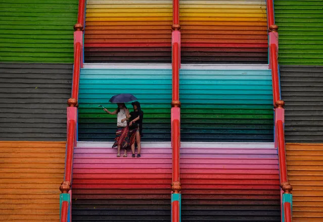 Visitors are seen take their picture on the 272-step stairs leading up to the Sri Subramaniar Swamy temple are painted with bright colors on September 1, 2018 in Batu Caves, Malaysia. The Sri Subramaniar Swamy Temple are painted to resamble a rainbow and also given a colourfull new look for temple, a rejuvenations process which is performed once 12 years also is a part of Hindu ritual for their beleiver. (Photo by Mohd Samsul Mohd Said/Getty Images)