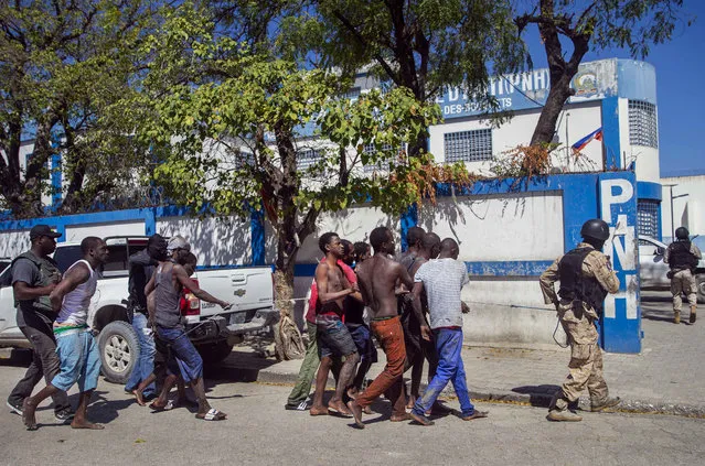 Recaptured inmates are escorted by police back to the Croix-des-Bouquets Civil Prison after an attempted breakout, in Port-au-Prince, Haiti, Thursday, February 25, 2021. (Photo by Dieu Nalio Chery/AP Photo)