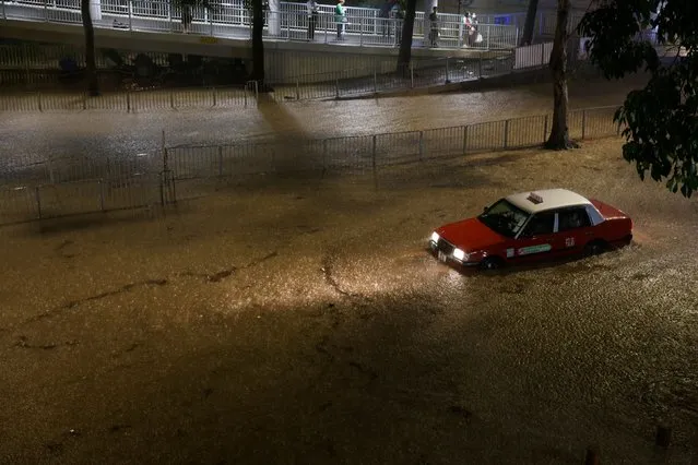 A taxi is seen at a flooded area during heavy rain, in Hong Kong, China on September 8, 2023. (Photo by Tyrone Siu/Reuters)
