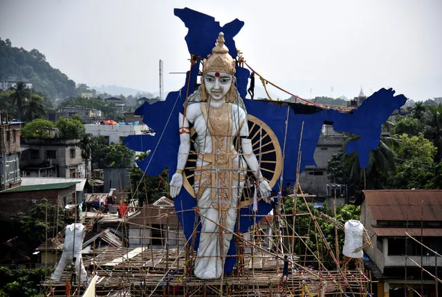 Labourers install a giant statue depicting "Mother India" at a pandal, or a temporary platform, ahead of the Durga Puja festival in Guwahati, India, October 2, 2018. (Photo by Anuwar Hazarika/Reuters)