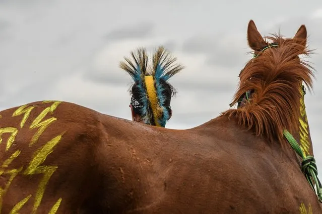 Kaden Bringsplenty brings his horse to the starting line as Native Americans from all over the United States participate in an Indian relay race over Memorial Day weekend at the Osage County Fairgrounds in Pawhuska, Oklahoma, U.S. May 30, 2021. (Photo by Stephanie Keith/Reuters)