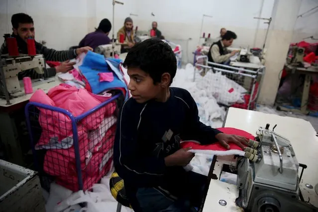 Employees work inside a garment factory in the besieged town of Douma, near Damascus, Syria, December 21, 2015. (Photo by Bassam Khabieh/Reuters)