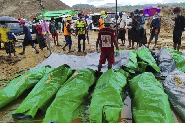 Recovered bodies of the victims of a landslide are shrouded in green plastic sheets at a jade mining area of Hpakant, Kachin state, Myanmar on Tuesday, August 15, 2023. (Photo by AP Photo/Stringer)