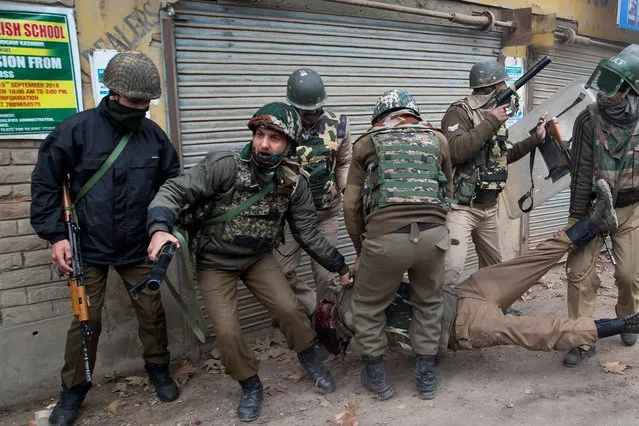 Indian paramilitary soldiers rush to help their colleague wounded during a clash with protestors near the site of a gunfight in Badgam district, Indian controlled Kashmir, Wednesday, November 28, 2018. Police in Indian administered Kashmir say they have killed an alleged Pakistani militant accused in the death of a prominent journalist. (Photo by Dar Yasin/AP Photo)
