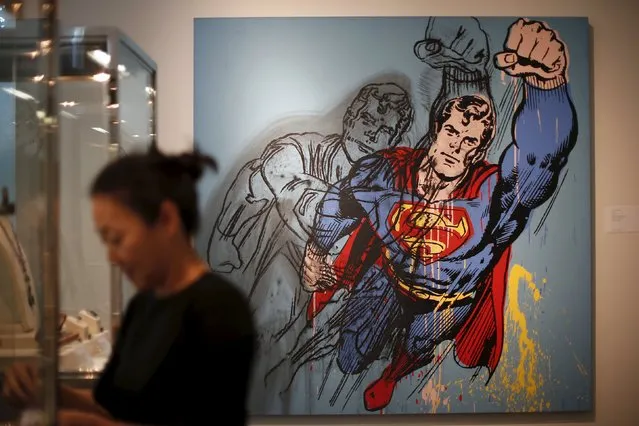 A woman stands in front of Andy Warhol's “Superman”, which is expected to fetch USD $6-8 million at a pre-auction viewing at Sotheby's in Los Angeles, California March 25, 2015. (Photo by Lucy Nicholson/Reuters)