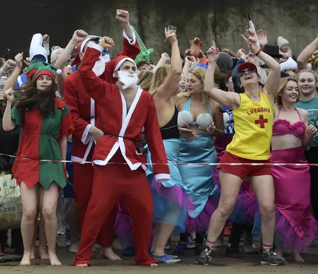 Competitors warm up before taking part in the New Year's Day swim at Saundersfoot in Wales, Britain, January 1, 2017. (Photo by Rebecca Naden/Reuters)