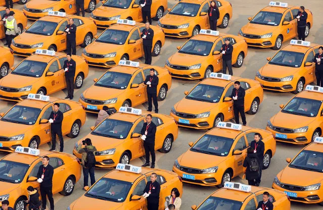 People attend an unveiling ceremony for a fleet of new methanol-fuelled taxis, developed by Geely, in Xian, Shaanxi province, China December 20, 2018. (Photo by Reuters/China Stringer Network)