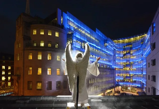 BBC handout photo of Cast member Kathy Longbottom as the Angel Gabriel from the Wintershall Nativity play appears on the roof of the All Souls Church during their performance outside the BBC Broadcasting House, London, on December 19, 2013. (Photo by Jeff Overs/BBC/PA Wire)