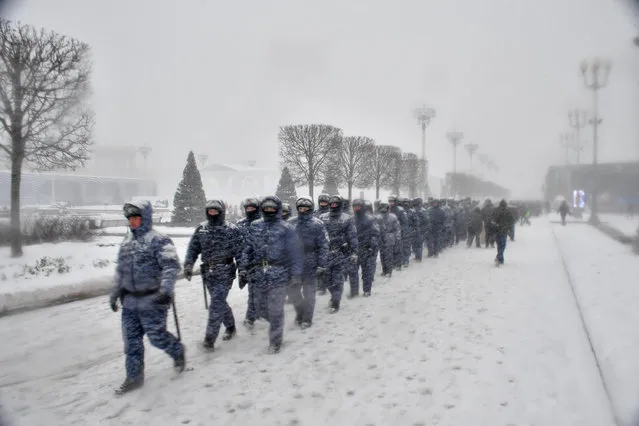 Russian Rosguardia (National Guard) servicemen walk at VDNKh, The Exhibition of Achievements of National Economy during heavy snowfall in Moscow, Russia, Monday, December 4, 2023. A record snowfall has hit Russia's capital bringing an additional 10 cm (3,9 inches) to already high levels of snow and causing disruption at the capital's airports and on roads. (Photo by Sergei Kiselev/Moscow News Agency via AP Photo)