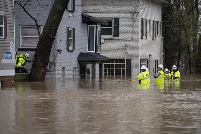 Technicians with Louisville Gas and Electric disconnect electric service from homes as flooding from the Ohio River inundated the area, Tuesday, February 12, 2019, near Louisville, Ky. (Photo by Bryan Woolston/AP Photo)