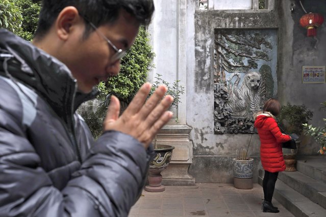 A man prays at the Quan Thanh Temple in Hanoi, Vietnam, Sunday, February 24, 2019. (Photo by Vincent Yu/AP Photo)