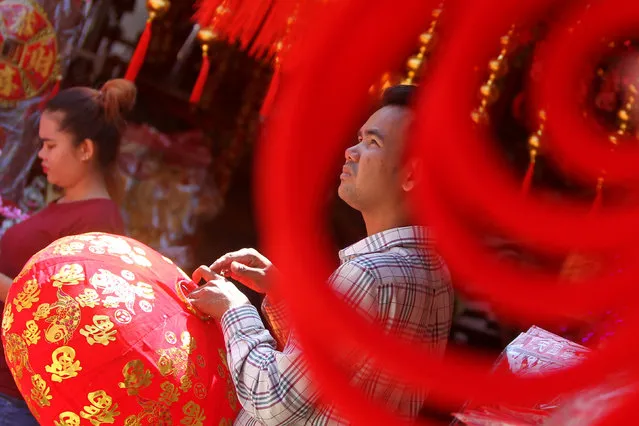A man is seen selling goods in a decorations market during Lunar New Year eve in Phnom Penh, Cambodia January 27, 2017. (Photo by Samrang Pring/Reuters)