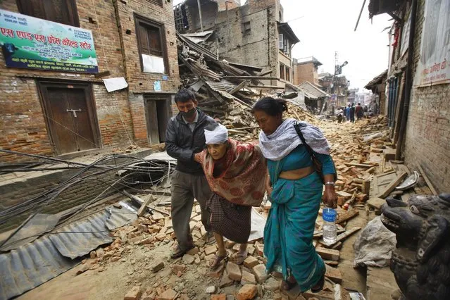 An elderly injured woman is taken to her home after treatment in Bhaktapur near Kathmandu, Nepal, Sunday, April 26, 2015. (Photo by Niranjan Shrestha/AP Photo)