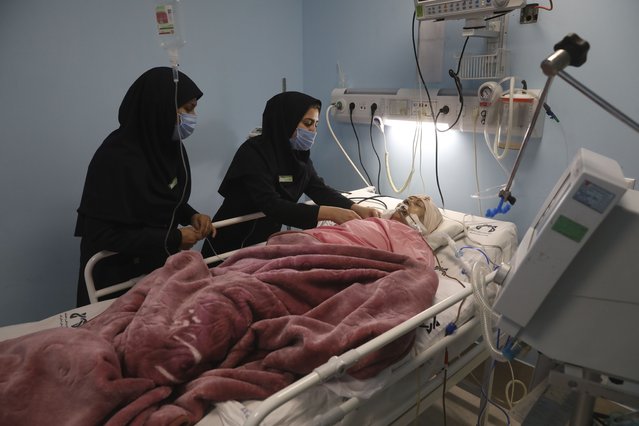 Covid-19 patient Marhamat Asadi which is in medically induced coma is tended by nurses Fatemeh Najmeh Sadeghi, left, and Fereshteh Babakhanlou at the COVID-19 ICU ward of Amir Al-Momenin hospital in the city of Qom, some 80 miles (125 kilometers) south of the capital Tehran, Iran, Wednesday, September 15, 2021. (Photo by Vahid Salemi/AP Photo)