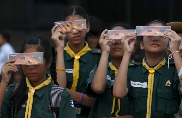 Students watch the solar eclipse through solar viewers in Bangkok, Thailand, March 9, 2016. (Photo by Chaiwat Subprasom/Reuters)