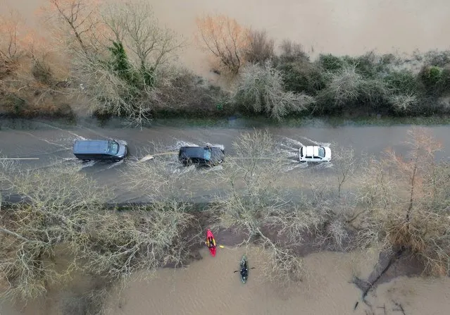 Kayakers look on from flooded land as motorists drive along a partially flooded road after the River Arun burst its banks in the aftermath of Storm Henk, at Pulborough, Britain on January 6, 2024. (Photo by Toby Melville/Reuters)