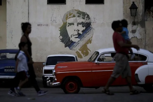 People walk past a painting of late revolutionary hero Ernesto “Che” Guevara in Havana, March 16, 2016. (Photo by Ueslei Marcelino/Reuters)