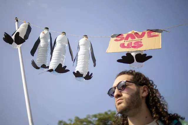 A man holds a display depicting dead penguins during a march demanding the world leaders to take action in reversing climate change and stop the use of fossil fuels in Tel Aviv, Israel, Friday, October 29, 2021. Thousands of Israelis gathered Friday in Tel Aviv to take part in a worldwide day of action before leaders head to the Scottish city of Glasgow for the start of the U.N. Climate Change Conference, known as COP26. (Photo by Ariel Schalit/AP Photo)