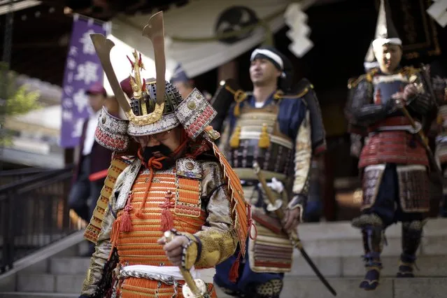 Men dressed as samurai warriors in armor walk out after the Kachiya Festival at Katori Shrine in Tokyo Tuesday, May 5, 2015. The festival celebrates that the warlord Fujiwara Hidesato made for victory over warload Taira no Masakado's revolt in 940 during the Heian Period (794-1185) and then, Fujiwara dedicated a “kachiya” or victory arrow to the shrine. (Photo by Eugene Hoshiko/AP Photo)