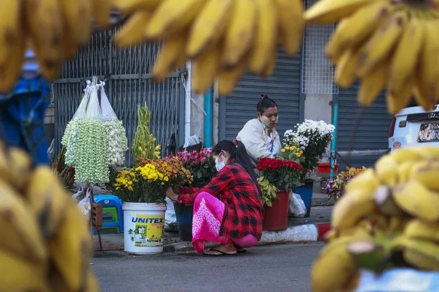 Woman arrange flowers at a street market in Yangon, Myanmar, on February 2, 2021. Myanmar was a rising star in Southeast Asia before its military seized power three years ago in a takeover that has brought civil strife and a tightening vise of sanctions, undoing years of progress and leaving the economy 10% smaller than it was in 2019. (Photo by Thein Zaw/AP Photo)