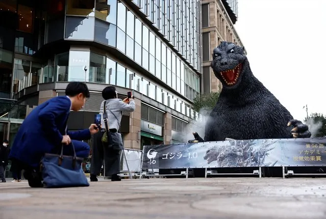 People take photos of a Godzilla statue which is installed to promote the film “Godzilla Minus One” after the movie won the Oscar for Best Visual Effects during the Oscars show at the 96th Academy Awards in Hollywood, in Tokyo, Japan, on March 11, 2024. (Photo by Issei Kato/Reuters)