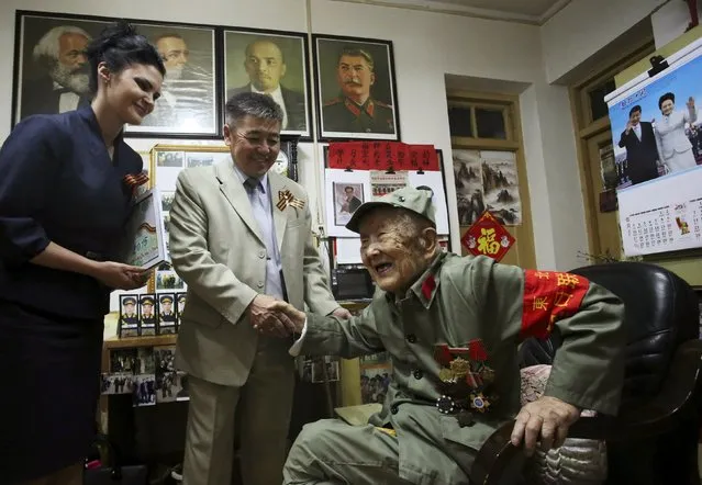 Lu Baoping, a 97-year-old Chinese veteran who fought against Japan during World War Two, shakes hands with a Russian diplomat as he receives a commemorative medal marking the 70th anniversary of the victory of the Great Patriotic War, in Yichang, Hubei province, China, May 7, 2015. (Photo by Reuters/Stringer)