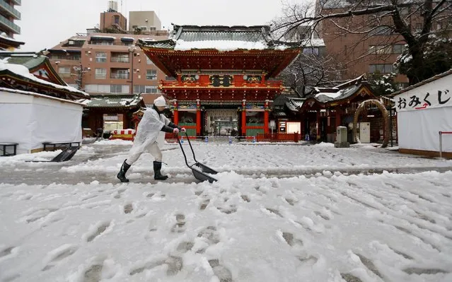 A man clears snow from a walkway at Kanda Miyojin Shrine in Tokyo, Japan January 18, 2016. (Photo by Toru Hanai/Reuters)