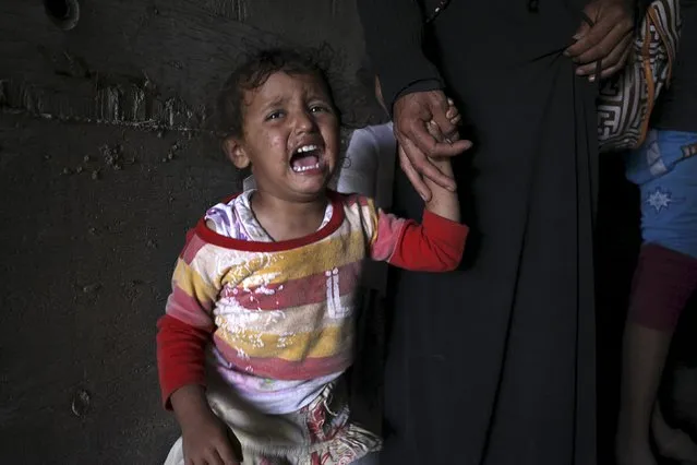 A girl cries next to her mother as they sit inside an underground water tunnel with other displaced Yemeni families, after they were forced to flee their home due to ongoing air-strikes carried out by the Saudi-led coalition in Sanaa May 2, 2015. (Photo by Mohamed al-Sayaghi/Reuters)