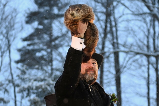 Punxsutawney Phil's handler A.J. Dereume holds up the famous groundhog during a socially distanced and remote event due to the coronavirus disease (COVID-19) on the 135th Groundhog Day at Gobblers Knob in Punxsutawney, Pennsylvania, U.S., February 2, 2021. (Photo by Alan Freed/Reuters)