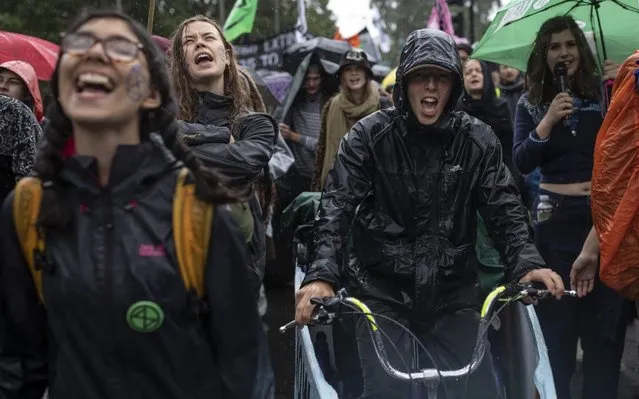 Extinction Rebellion protesters march to Westminster through heavy rain at the end of their week-long protests on July 19, 2019 in London, United Kingdom. Extinction Rebellion are a socio-political movement which uses civil disobedience and nonviolent resistance to protest against climate breakdown, biodiversity loss, and the risk of social and ecological collapse. (Photo by Dan Kitwood/Getty Images)