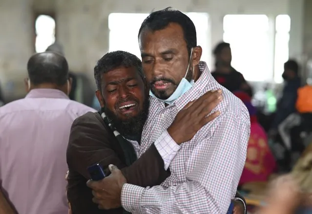 A person consoles his relative who is unable to find his five years old son travelling in a ferry which caught fire, at a government medical hospital, in Barishal, Bangladesh, Friday, December 24, 2021. Bangladesh fire services say at least 37 passengers have been killed and many others injured in a massive fire that swept through a ferry on the southern Sugandha River. The blaze broke out around 3 a.m. Friday on the ferry packed with 800 passengers. (Photo by Niamul Rifat/AP Photo)