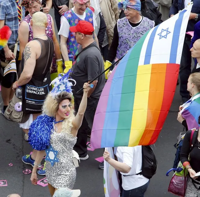 A participant carries an Israeli flag stitched to a rainbow flag at the annual Christopher Street Day parade on Kurfuerstendamm in Berlin, Germany, June 27, 2015. (Photo by Fabrizio Bensch/Reuters)