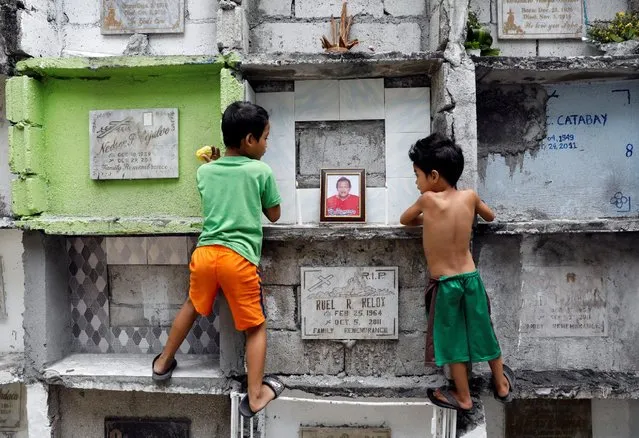 Boys look at the tomb of Michael Almeda, who was among those allegedly killed by the Bonnet Gang, in more than 60 drug-related vigilante killings in the town of Pateros, Metro Manila, Philippines March 15, 2017. (Photo by Erik De Castro/Reuters)