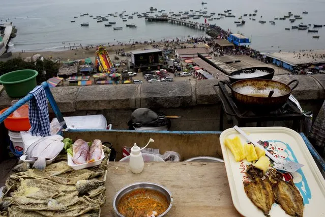 Fish and yucca are displayed for sale at a street food stand during Saint Peter's Day celebrations in Lima, Peru, Monday, June 29, 2015. (Photo by Rodrigo Abd/AP Photo)