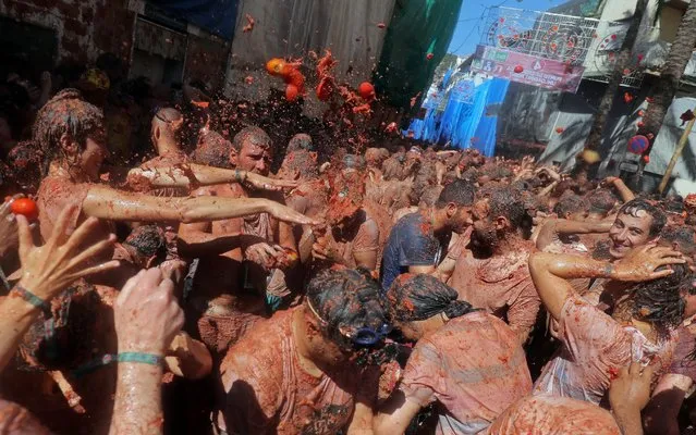 Revelers throw tomatoes during the annual “La Tomatina” tomato food fight festival in Bunol, near Valencia, Spain on August 28, 2019. (Photo by Juan Medina/Reuters)