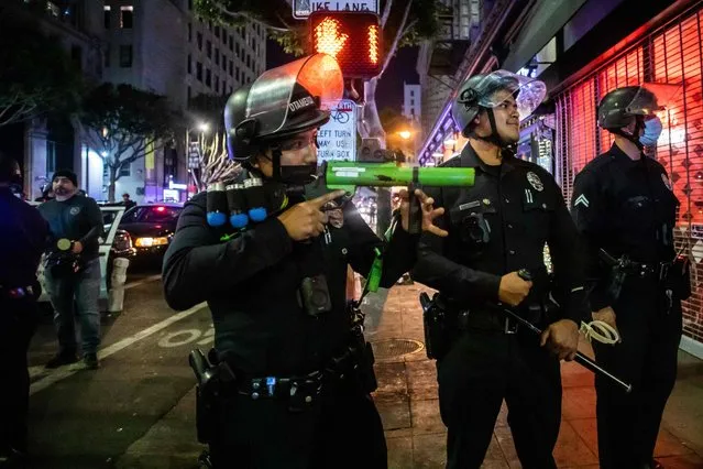 Police officers take position to disperse LA Rams fans in downtown Los Angeles after the Los Angeles Rams won the Super Bowl LVI against Cincinnati Bengals on February 13, 2022. (Photo by Apu Gomes/AFP Photo)