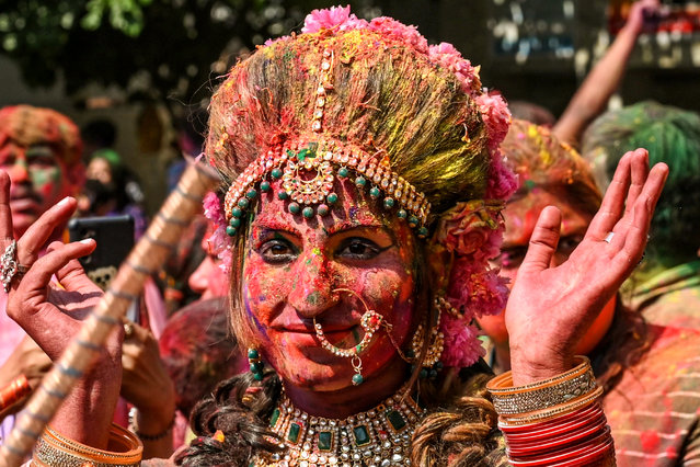 An artist dressed as goddess Radha dance along with devotees during celebrations for Holi, the Hindu spring festival of colours, at a temple in Amritsar, India on March 8, 2023. (Photo by Narinder Nanu/AFP Photo)