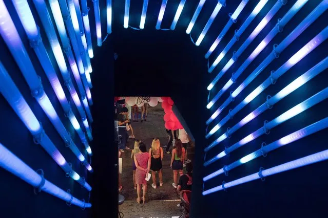 This photo taken on March 29, 2017 shows women standing in the entrance to a go go dance bar to entice customers to enter in Walking Street in Pattaya. (Photo by Roberto Schmidt/AFP Photo)