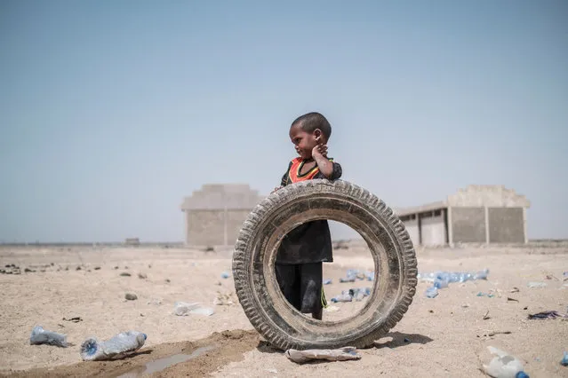 An internally displaced child stands next to tire in a school in the village of Afdera, 225 kms of Semera, Ethiopia, on February 15, 2022. More than fifteen months since the first shots rang out, foreign envoys are talking up paths to peace for Ethiopia while Prime Minister Abiy Ahmed publicly refers to the conflict in the past tense. (Photo by Eduardo Soteras/AFP Photo) 