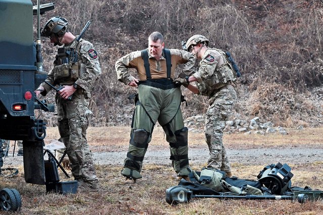 A US soldier puts on a bomb suit as his team compete in the “EOD Team of the Year Competition” to evaluate EOD (Explosive Ordnance Disposal) teams of US Forces Korea at the US army's Rodriguez shooting range in Pocheon on March 15, 2022. (Photo by Jung Yeon-je/AFP Photo)