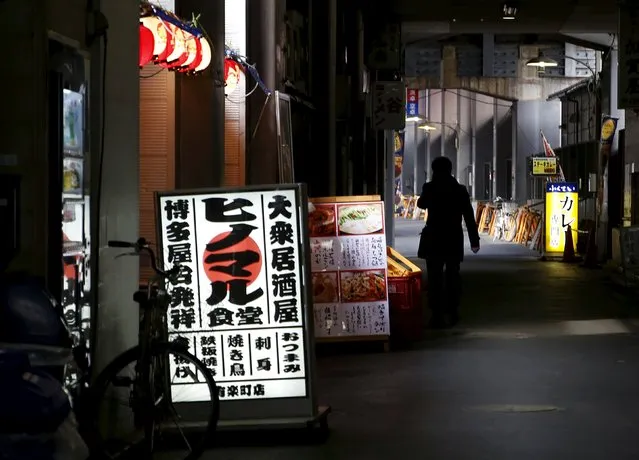 A man holding his mobile phone walks on a side street of Ginza shopping district in Tokyo, Japan, March 28, 2016. (Photo by Yuya Shino/Reuters)
