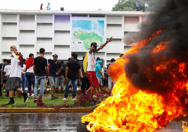 Demonstrators gather next to a burning roadblock during protests against election results, in Puerto La Cruz, Venezuela on July 29, 2024. (Photo by Samir Aponte/Reuters)