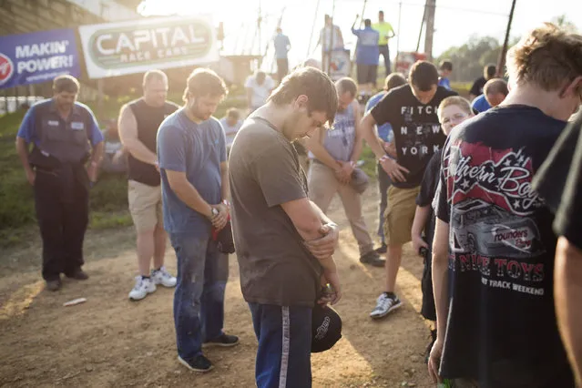 In this July 17, 2015 photo, drivers hold a pre-race prayer at the Ponderosa Speedway in Junction City, Ky. The Speedway, in operation since 1972, is among a handful of dirt racetracks sprinkled across Kentucky where weekend drivers, their crews and families can test their mechanical and driving skills. (Photo by David Stephenson/AP Photo)