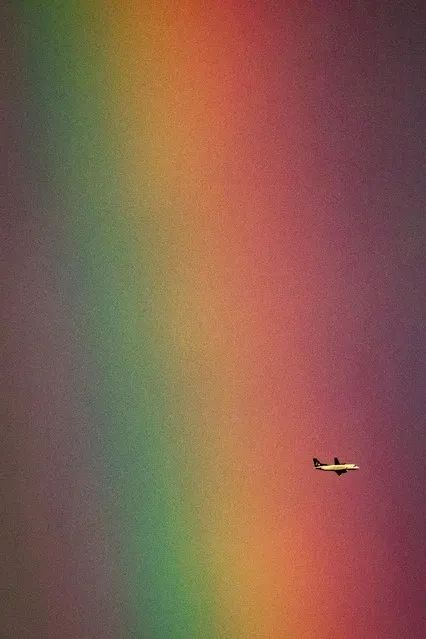 A Pacific Coastal Airlines flight arriving from Port Hardy passes in front of a rainbow in Burnaby before landing at Vancouver International Airport in Richmond, British Columbia, on Thursday, November 4, 2021. (Photo by Darryl Dyck/The Canadian Press via AP Photo)
