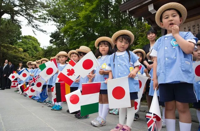 A group of school children wait for the G7 leaders to arrive for their tour of the Ise-Jingu Shrine in the city of Ise in Mie prefecture, on May 26, 2016 on the first day of the G7 leaders summit. World leaders kick off two days of G7 talks in Japan on May 26 with the creaky global economy, terrorism, refugees, China's controversial maritime claims, and a possible Brexit headlining their packed agenda. (Photo by Doug Mills/AFP Photo)