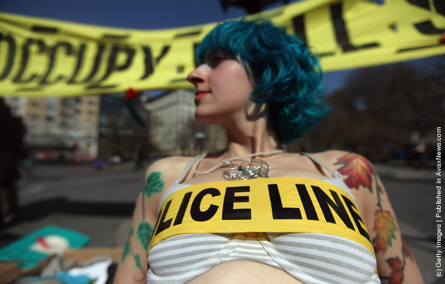 Protester Lauren Digioia wears police tape during an Occupy Wall Street protest in Union Square in New York City