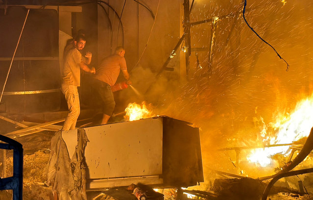 Palestinians work to extinguish a fire at the site of an Israeli strike on a tent camp for displaced people, amid the Israel-Hamas conflict, in Deir Al-Balah in the central Gaza Strip, on August 4, 2024. (Photo by Abdullah Al-Attar/Reuters)