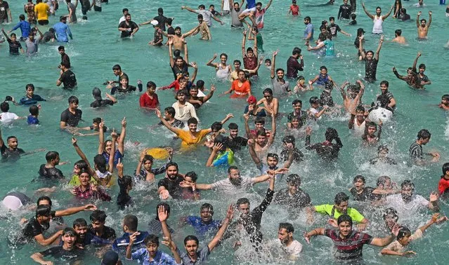 People cool off at a swimming pool during a hot summer day in Lahore on April 28, 2022. (Photo by Arif Ali/AFP Photo)