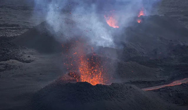 Lava erupts from the Piton de la Fournaise “Peak of the Furnace” volcano, on the southeastern corner of the Indian Ocean island of Reunion Saturday, August 1, 2015. (Photo by Ben Curtis/AP Photo)